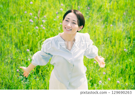 Young woman stretching in the grassland Lifestyle image Young woman stretching in the grassland Lifestyle image 129690263