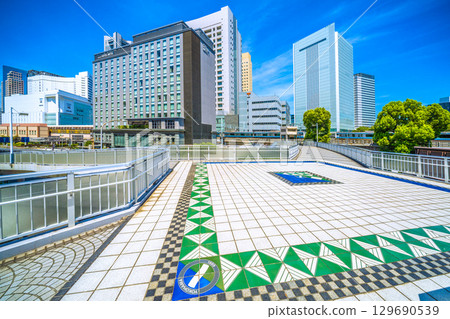 Yokohama cityscape in Japan: View of Sakuragicho Station's New South Exit (City Hall Exit), Hotel Mets, Yokohama City Hall, and trains going up and down the line. Yokohama cityscape in Japan: View of Sakuragicho Station's New South Exit (City Hall Exit), Hotel Mets, Yokohama City Hall, and trains going up and down the line. 129690539