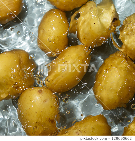Raw Potatoes In Water Splash Macro Top View. 129690662