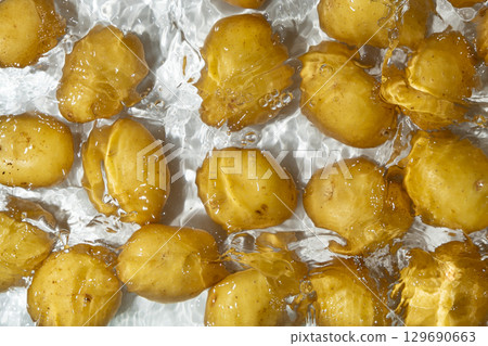 Fresh Organic Potatoes Immersed In Water With Splashing Effect. Fresh Organic Potatoes Immersed In Water With Splashing Effect. 129690663