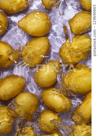 Whole Organic Raw Potatoes In Water Top View, Splash And Ripples. 129690665