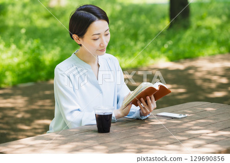 Young woman reading outdoors Lifestyle image Young woman reading outdoors Lifestyle image 129690856