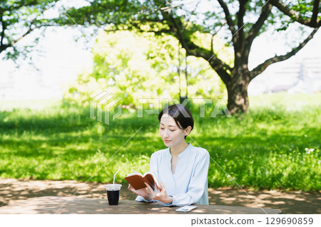 Young woman reading outdoors Lifestyle image Young woman reading outdoors Lifestyle image 129690859