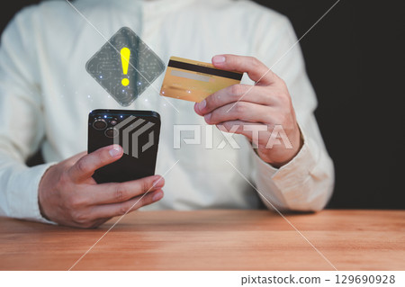 Adult man holding a credit card and mobile phone with a warning sign overlay, symbolizing online scams, fraud, security risks, transfer money and financial caution in digital transactions. Adult man holding a credit card and mobile phone with a warning sign overlay, symbolizing online scams, fraud, security risks, transfer money and financial caution in digital transactions. 129690928