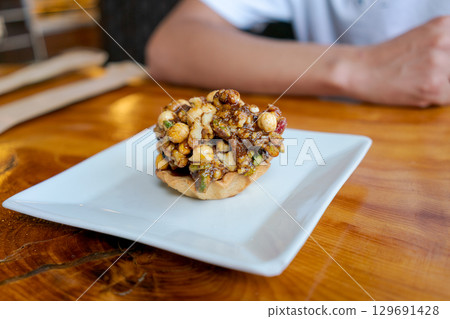 Plate of food with nuts and a piece of bread 129691428