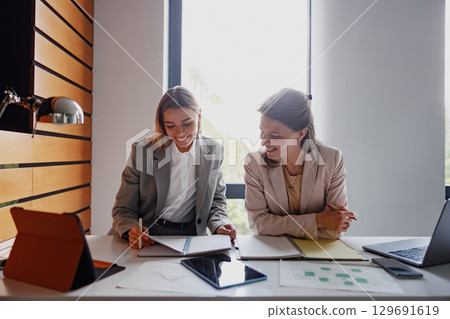 Engaging and collaborative business meeting set in a modern and vibrant office environment Engaging and collaborative business meeting set in a modern and vibrant office environment 129691619