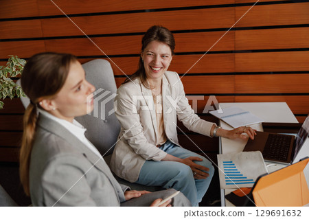 Engaging in a Collaborative Business Meeting Filled with Enthusiastic and Smiling Professionals Engaging in a Collaborative Business Meeting Filled with Enthusiastic and Smiling Professionals 129691632