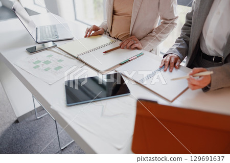 Engaging in a Collaborative Business Meeting with Laptops and Notebooks Present Throughout 129691637