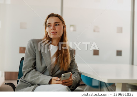 A Thoughtful and Ambitious Professional Woman working diligently in a Modern Office Setting A Thoughtful and Ambitious Professional Woman working diligently in a Modern Office Setting 129691822