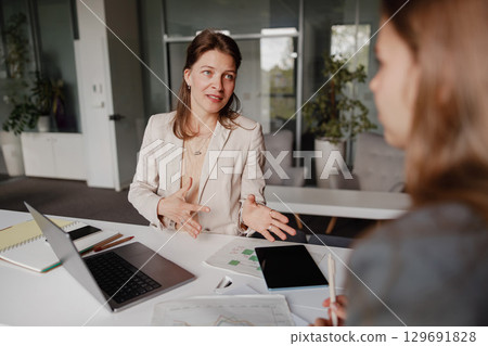 A Business Meeting Taking Place Among Professional Women Within a Modern Office Environment A Business Meeting Taking Place Among Professional Women Within a Modern Office Environment 129691828
