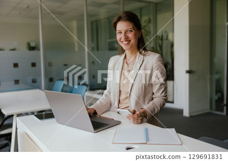 A Professional Woman Engaged in Work within a Modern Office Environment Using Her Laptop A Professional Woman Engaged in Work within a Modern Office Environment Using Her Laptop 129691831