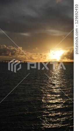 The sunset that colors the sky and sea of Miyakojima The silhouette of Irabu Bridge 129692450