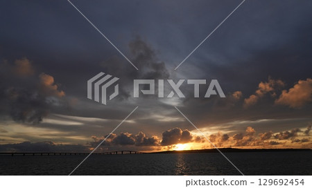 The sunset that colors the sky and sea of Miyakojima The silhouette of Irabu Bridge 129692454