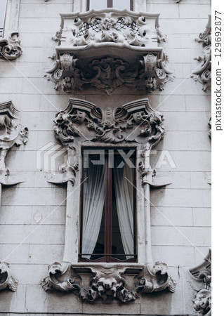Decorative balcony and window with elaborate stucco ornamentation on historic building facade. Decorative balcony and window with elaborate stucco ornamentation on historic building facade. 129692877