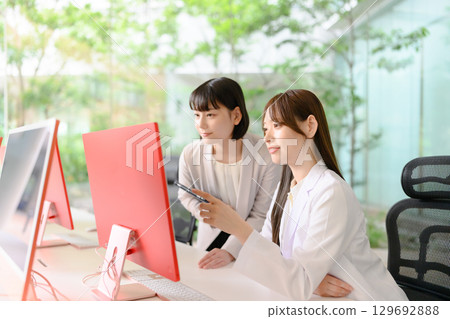A woman in a white coat and a woman in a jacket A woman in a white coat and a woman in a jacket 129692888