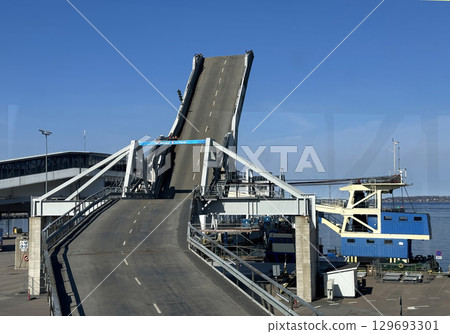 A ferry terminal ramp is raised high, waiting for the arrival of a ferry 129693301