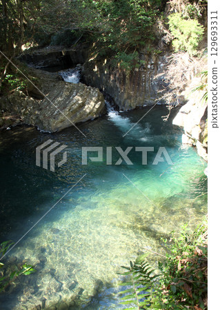 Clear stream flowing through the valley 129693311