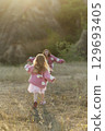 A young mother and daughter are walking in nature among the mountains in beautiful identical sweaters 129693405