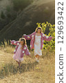 A young mother and daughter are walking in nature among the mountains in beautiful identical sweaters 129693422