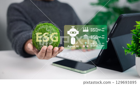 Hand holding ESG symbol with AI agent icons on tablet, representing sustainability, corporate governance, environmental responsibility, and digital technology integration. 129693895