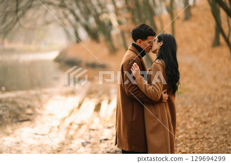 Young couple in love walking in the park on a autumn day. Enjoying time together. Young couple in love walking in the park on a autumn day. Enjoying time together. 129694299