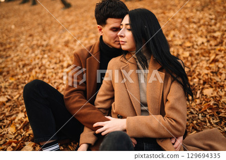 Young couple in love walking in the park on a autumn day. Enjoying time together. Young couple in love walking in the park on a autumn day. Enjoying time together. 129694335