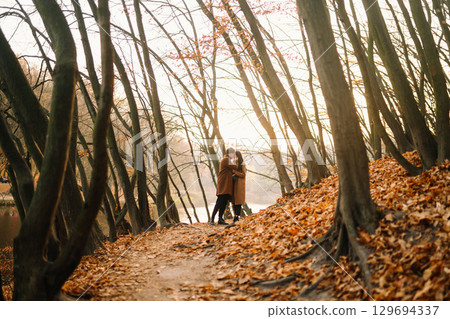 Young couple in love walking in the park on a autumn day. Enjoying time together. Young couple in love walking in the park on a autumn day. Enjoying time together. 129694337