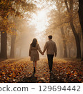 一男一女手牽手走在落葉地毯上的背影 129694442