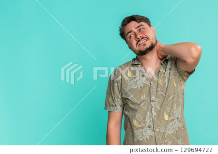 Adult man stretching back and massaging neck showing signs of fatigue muscle tension after long work 129694722