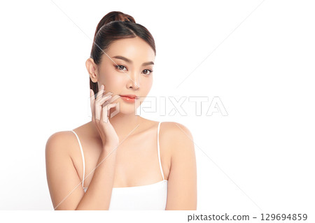 A beautiful young Asian woman with clean, fresh skin against a white background. Skincare, facial treatment, cosmetology, beauty, and spa. An elegant portrait of an Asian woman. A beautiful young Asian woman with clean, fresh skin against a white background. Skincare, facial treatment, cosmetology, beauty, and spa. An elegant portrait of an Asian woman. 129694859