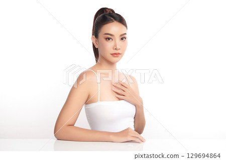 A beautiful young Asian woman with clean, fresh skin against a white background. Skincare, facial treatment, cosmetology, beauty, and spa. An elegant portrait of an Asian woman. A beautiful young Asian woman with clean, fresh skin against a white background. Skincare, facial treatment, cosmetology, beauty, and spa. An elegant portrait of an Asian woman. 129694864