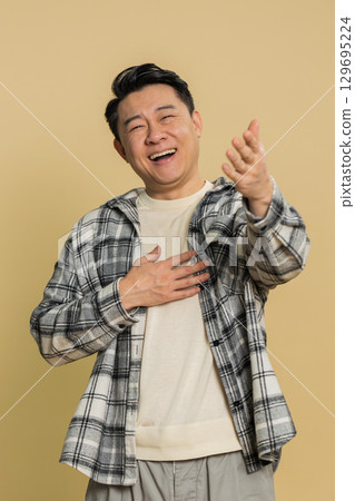 Amused smiling cheerful Asian man laughing out loud funny ridiculous joke anecdote bullying abuse Amused smiling cheerful Asian man laughing out loud funny ridiculous joke anecdote bullying abuse 129695224