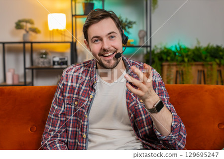 Caucasian man wearing headset freelance worker call center support service operator helpline at home Caucasian man wearing headset freelance worker call center support service operator helpline at home 129695247