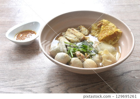 boiled dory fish and fishball with bean sprout topping crispy dumpling in soup on bowl dipping spicy chili soy paste sauce boiled dory fish and fishball with bean sprout topping crispy dumpling in soup on bowl dipping spicy chili soy paste sauce 129695261