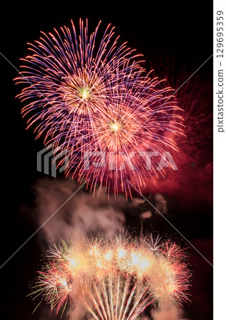 Large fireworks blooming in the night sky 129695359