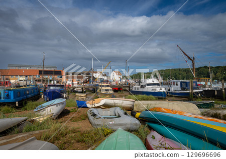 Colorful boats on a sunny day. View of the quay on the River Deben in the historic town of Woodbridge in Suffolk, UK. Colorful boats on a sunny day. View of the quay on the River Deben in the historic town of Woodbridge in Suffolk, UK. 129696696