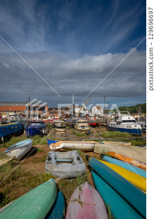 Colorful boats on a sunny day. View of the quay on the River Deben in the historic town of Woodbridge in Suffolk, UK. 129696697