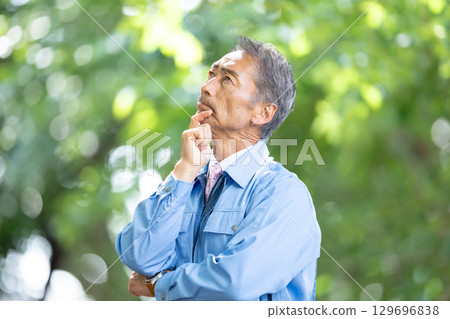 Man in work clothes, fresh green, worried Man in work clothes, fresh green, worried 129696838