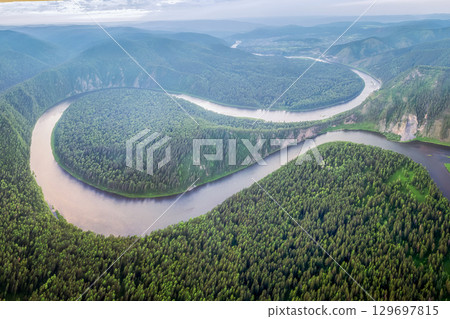 Captivating river bending through lush green forest landscapes at dawn in a remote mountainous area. The Mana River and the Manskaya Loop in Siberia, Russia Krasnoyarsk. 129697815