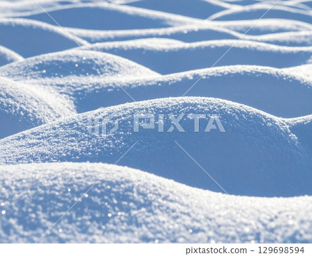 Snowy White Landscape of Rolling Hills and Sparkling Frost On a Cold Sunny Day 129698594