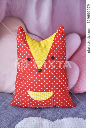 Colorful polka dot fox pillow with yellow accents on cozy bedding Colorful polka dot fox pillow with yellow accents on cozy bedding 129699979