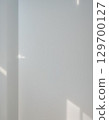 A minimalist landscape of light and shadows from a window reflected on a white wall 129700127