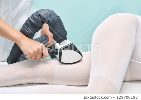 Female receiving cellulite treatment on legs with modern device in spa setting Female receiving cellulite treatment on legs with modern device in spa setting 129700188