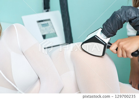 Female receiving body sculpting treatment in clinic with advanced technology Female receiving body sculpting treatment in clinic with advanced technology 129700235