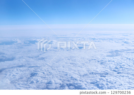 Expansive aerial view of white fluffy clouds with blue sky background Expansive aerial view of white fluffy clouds with blue sky background 129700236