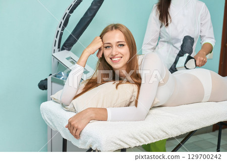 Young caucasian female enjoying laser therapy treatment for skin rejuvenation 129700242