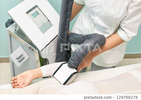 Female technician perform cryotherapy on caucasian female arm in spa clinic Female technician perform cryotherapy on caucasian female arm in spa clinic 129700278