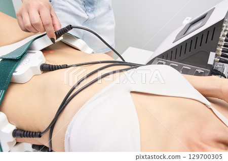 Female undergoing non-invasive laser treatment for body contouring in clinical 129700305