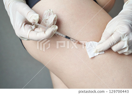 close up of injection procedure in medical setting with gloved hands 129700443