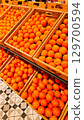 An abundant pile of fresh oranges. Fruits on a market stall. Eco food, vegetarian lifestyle, organic nutrition, and healthy eating. 129700594